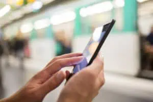 Smart Automations | Woman using her cell phone on subway platform